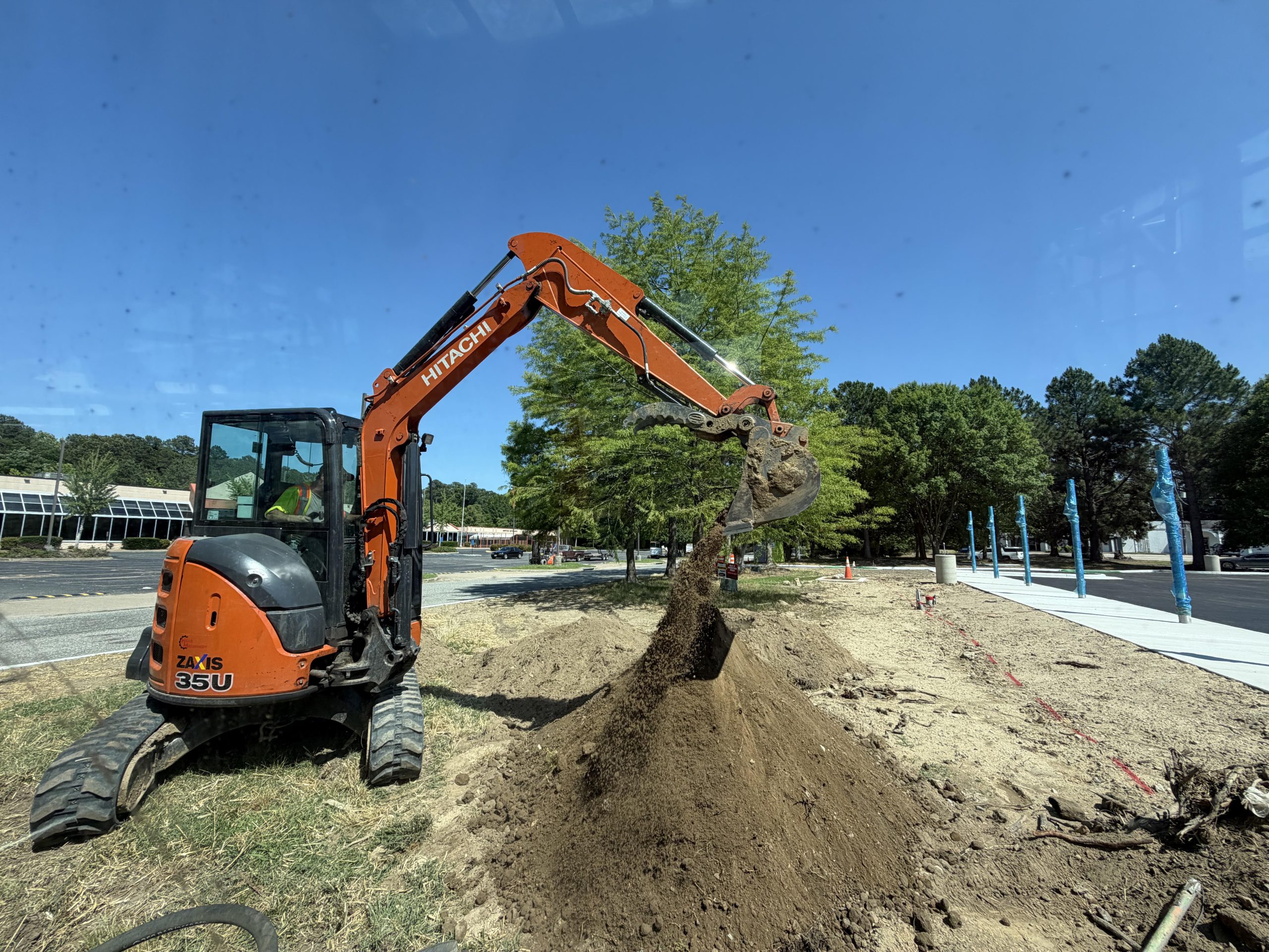 Excavator digging near trees during a Sturtz Contracting excavation project