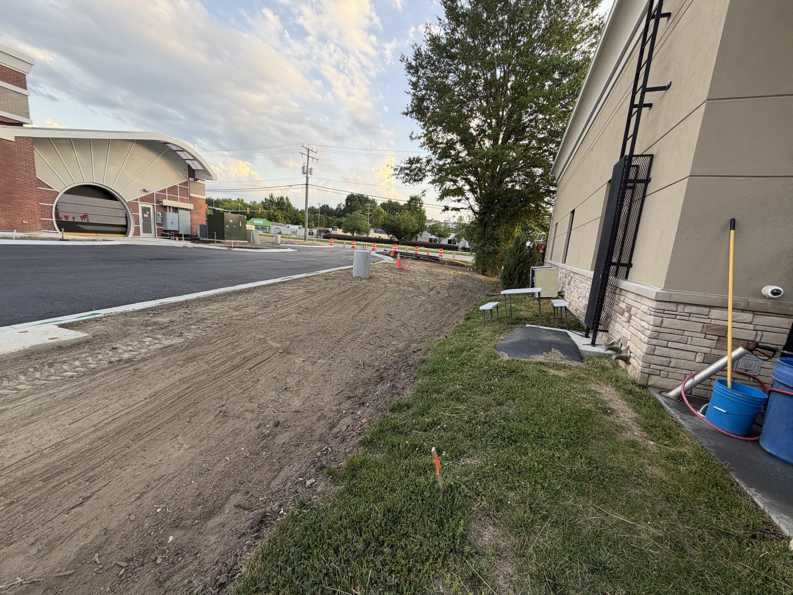 Dirt trench dug alongside a commercial building foundation for utility work