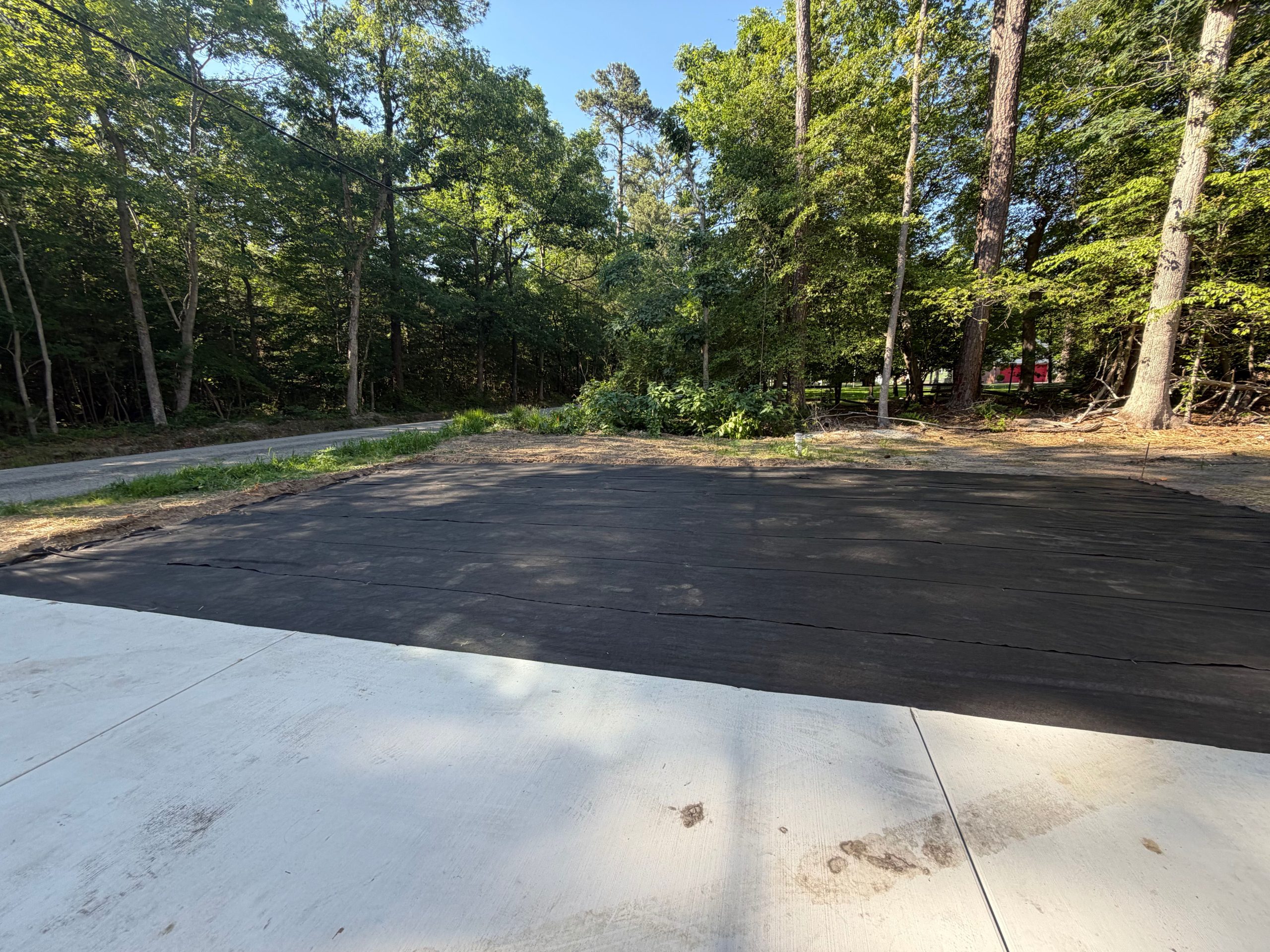New asphalt driveway pour next to existing concrete